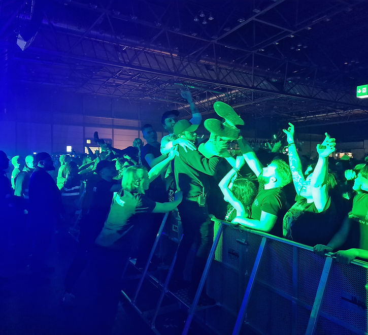 Crew fängt einen Crowdsurfer am Absperrgitter vor der Bühne auf
